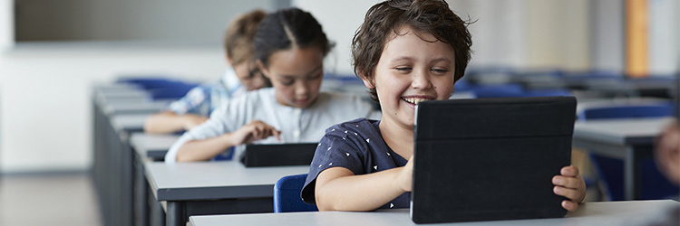 young boy playing on tablet in class