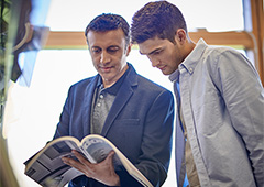 Male teacher reading with a student