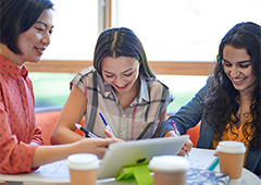 Female teacher working with two female students