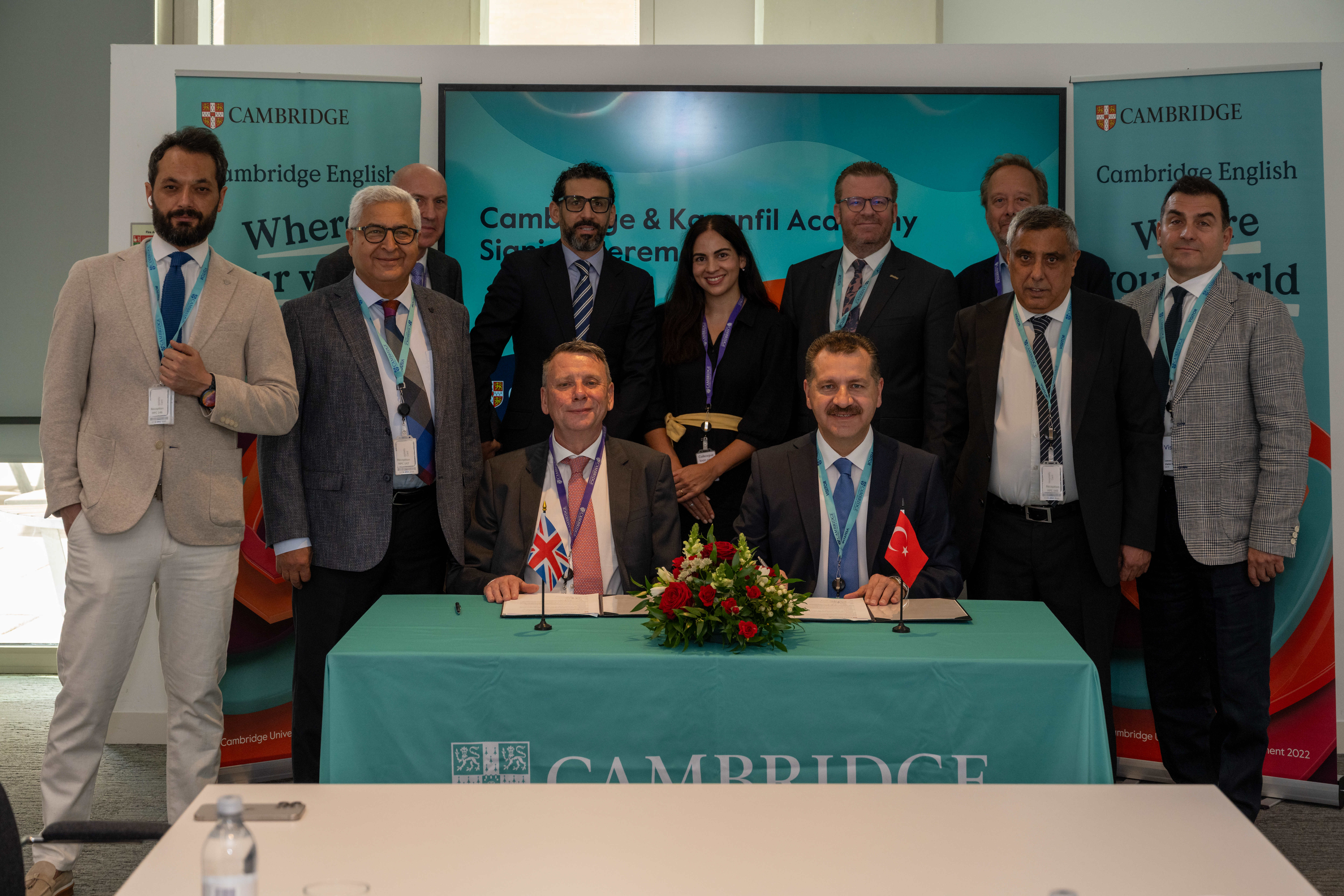 People at Cambridge University table during Karanfil Academy signing event.