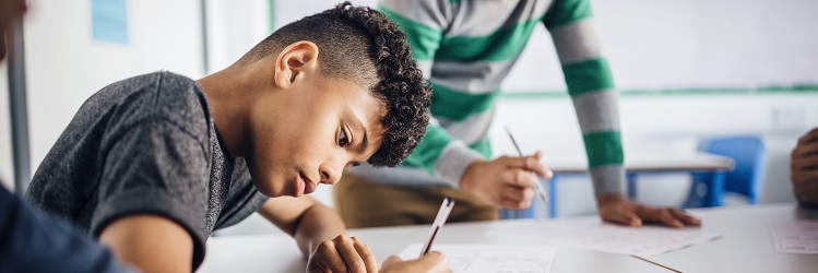 young learner writing in a classroom