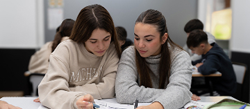 Student speaking English in class, demonstrating B2-level communication skills.