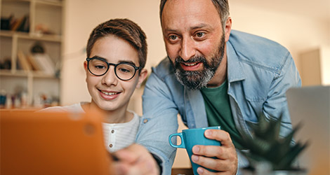 parent and teenager working on a computer