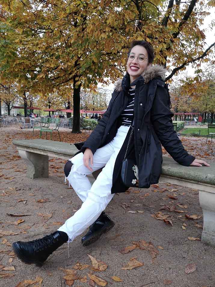 Andreza sitting on a bench in autumn