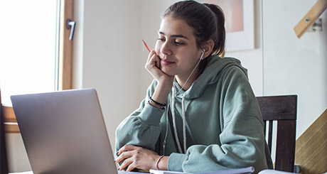 student on laptop with headphones