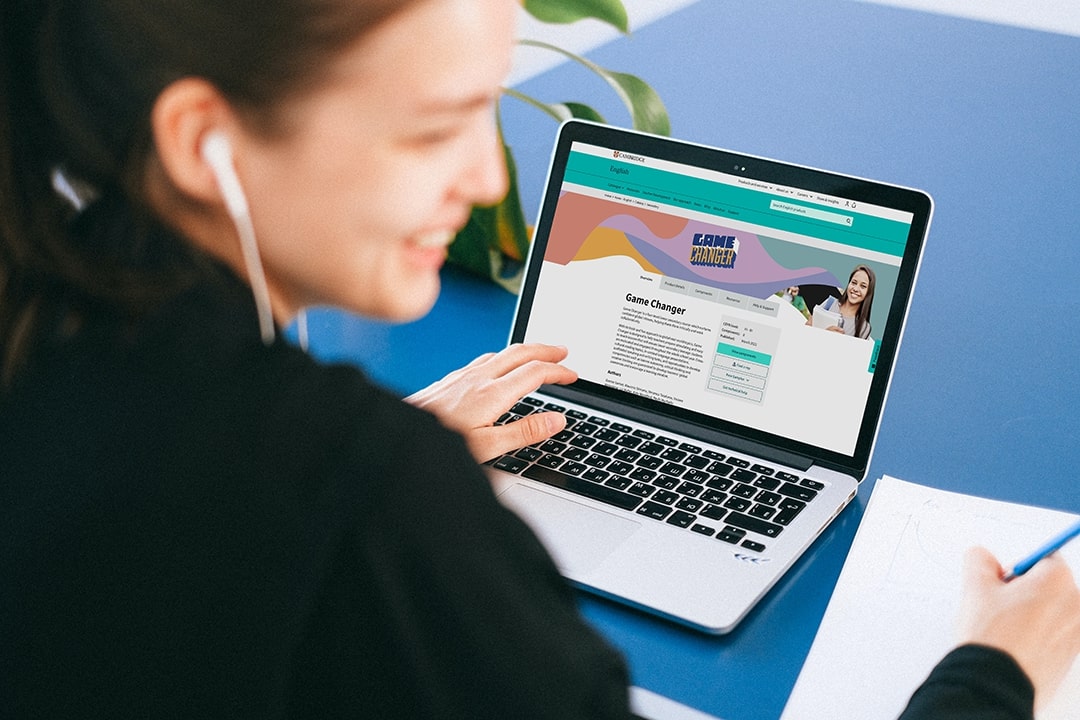 Learner using official Cambridge exam resources on a laptop.