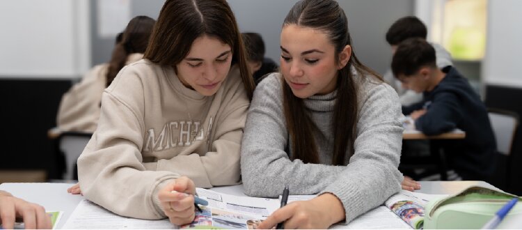 Two students studying together in a classroom.