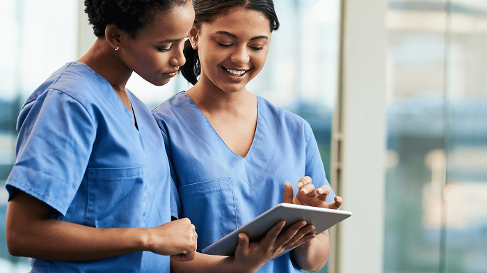 Two nurses reviewing a tablet