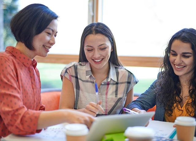 Group of colleagues discussing work around a tablet