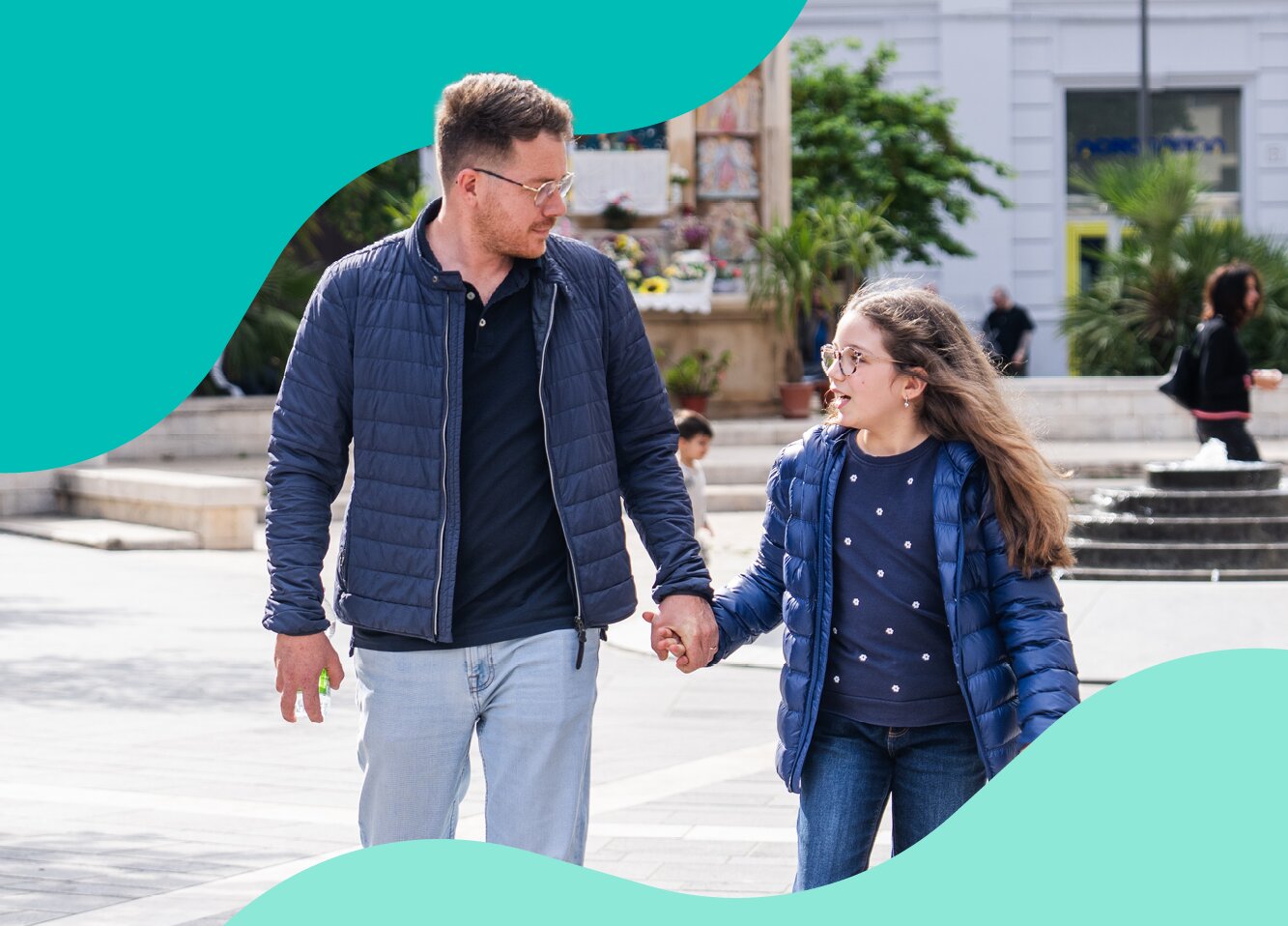 Adult and child walking together outdoors.