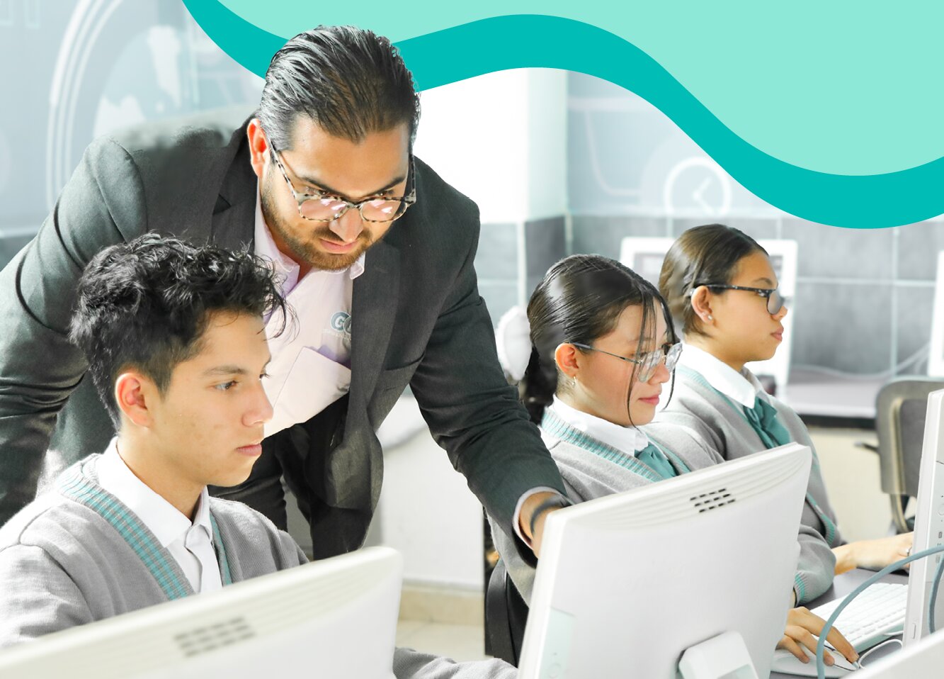 Teacher helping students in a computer lab.