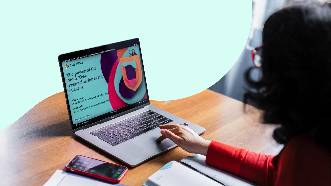 Person using a laptop to attend an online Cambridge webinar at a desk.