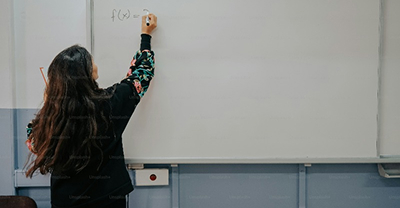 Person writing on a whiteboard.