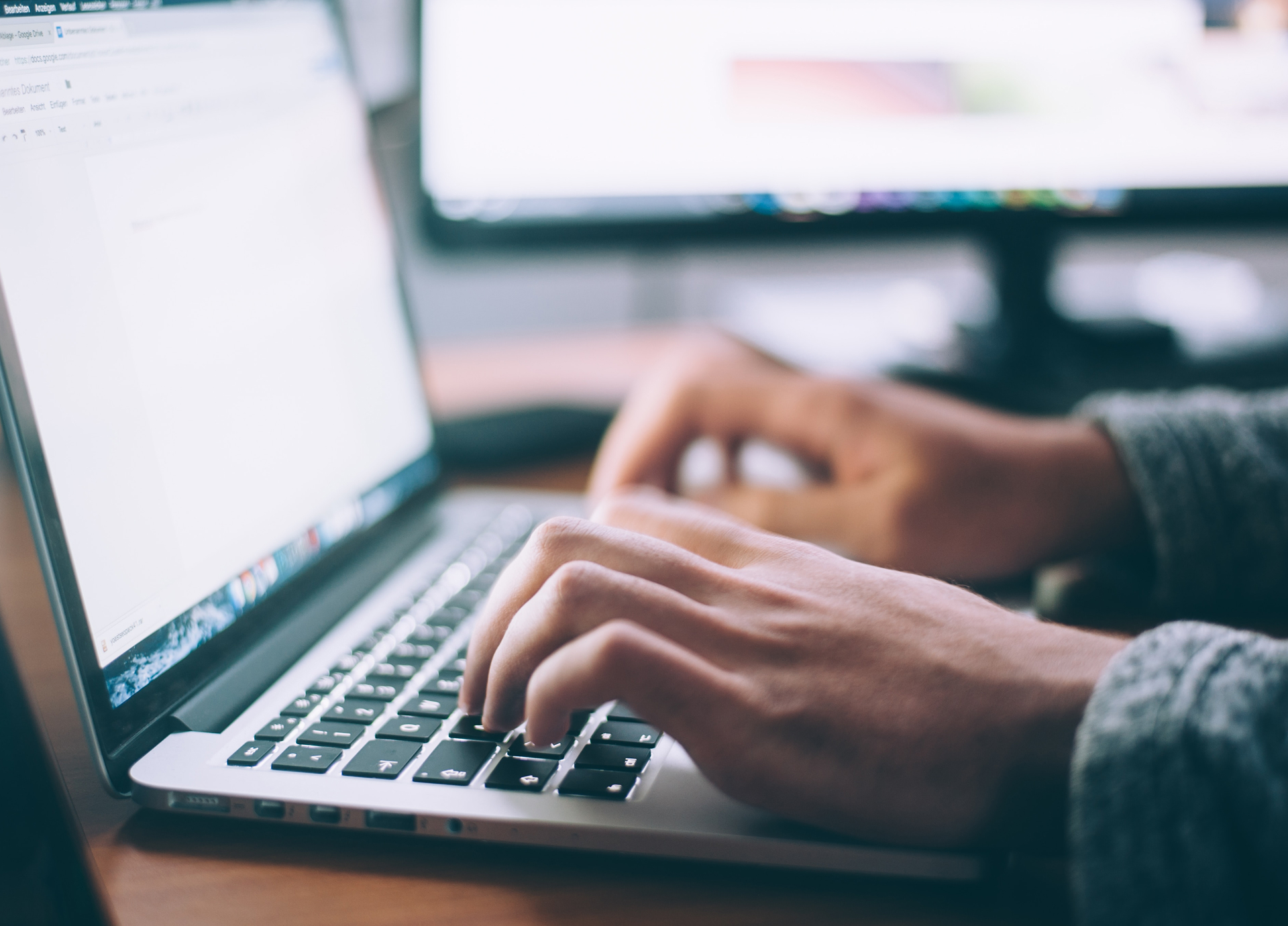 Person typing newsletter content on laptop