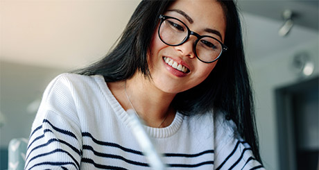 student in glasses writing