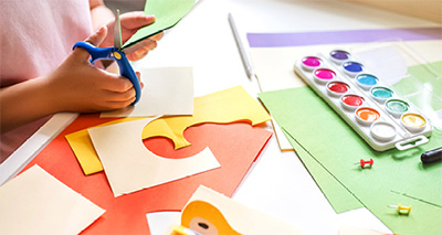 child with scissors and paints