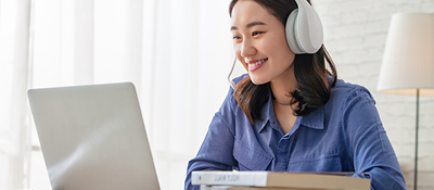 Woman on a laptop listening to headphones