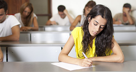 student wearing yellow top sitting in exam