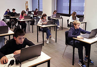 Estudiantes utilizando sus portátiles en un aula de Cambridge English