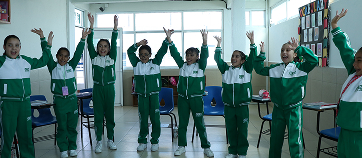 Jóvenes estudiantes practicando inglés en una actividad escolar.