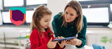 Person helping a child use a tablet.