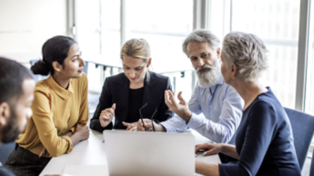 Équipe de professionnels en pleine discussion assis à une table.