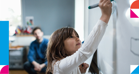 young learner writing on a board in class