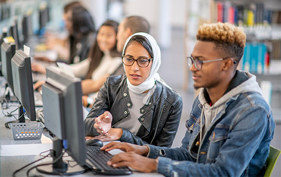 Male and female student working together at a computer