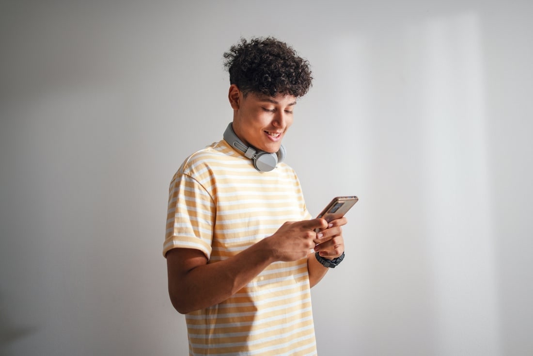 Un joven mira un teléfono.
