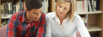  Teacher helping a student studying English in a library