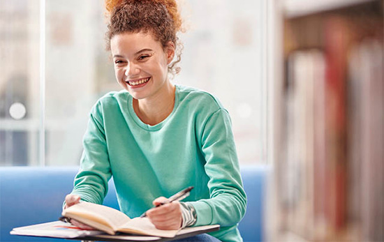 Redhead girl writing in a book